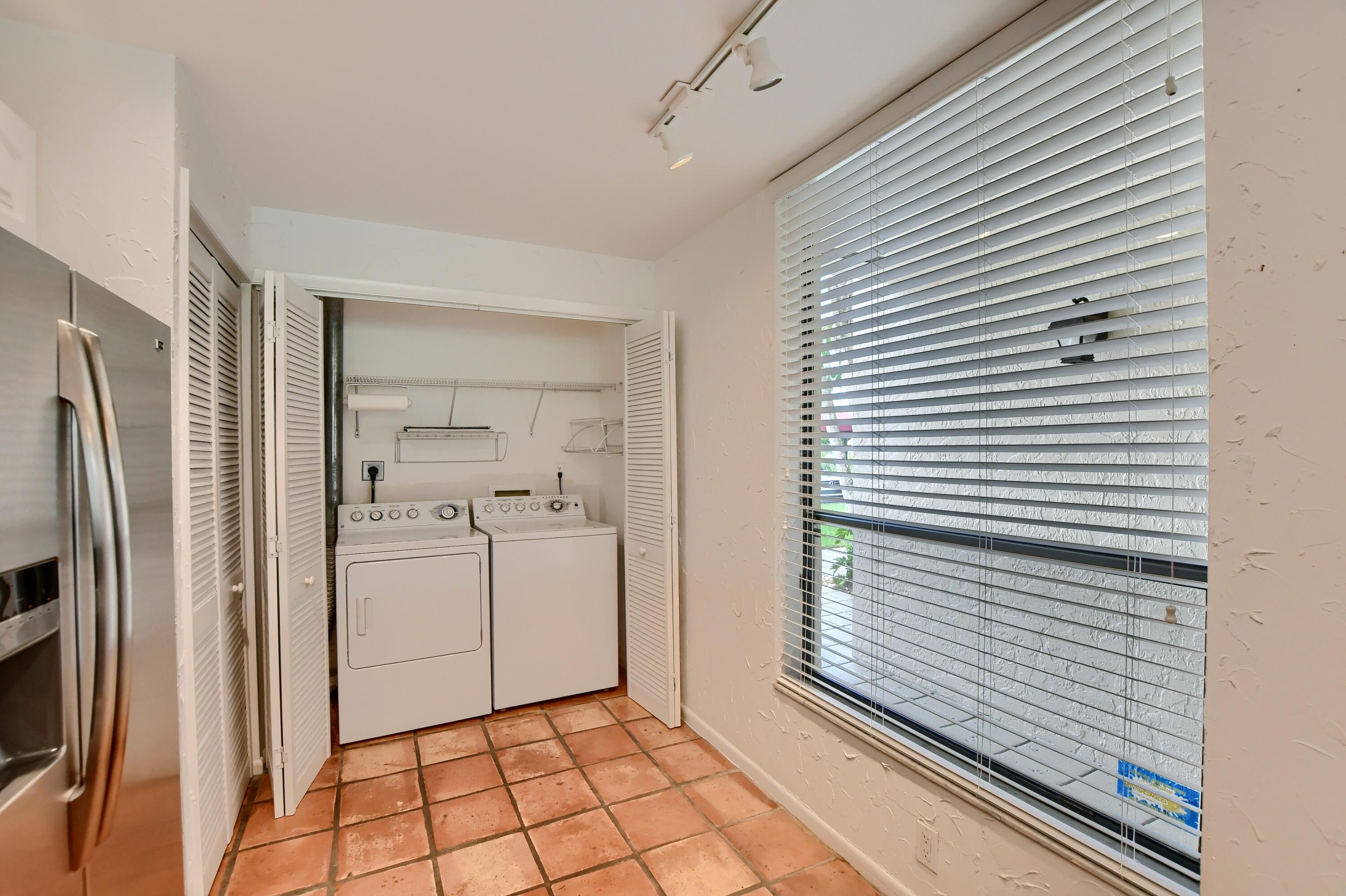 7495 La Paz Boulevard, Unit 105 Boca Raton, FL 33433 - Photo 14 of 29 a view of a kitchen with refrigerator and white cabinets