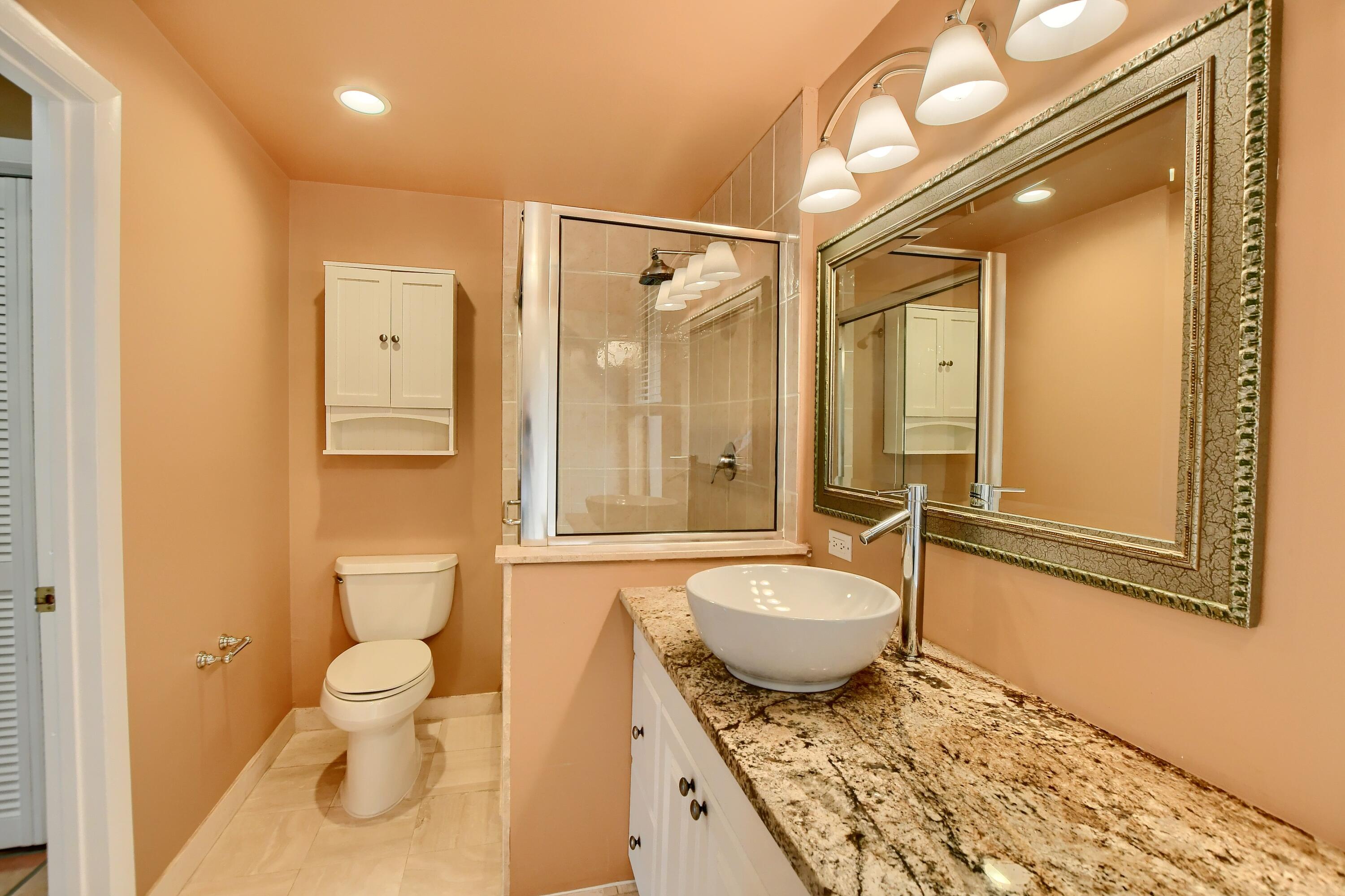 7495 La Paz Boulevard, Unit 105 Boca Raton, FL 33433 - Photo 22 of 29 a bathroom with a granite countertop sink and a mirror
