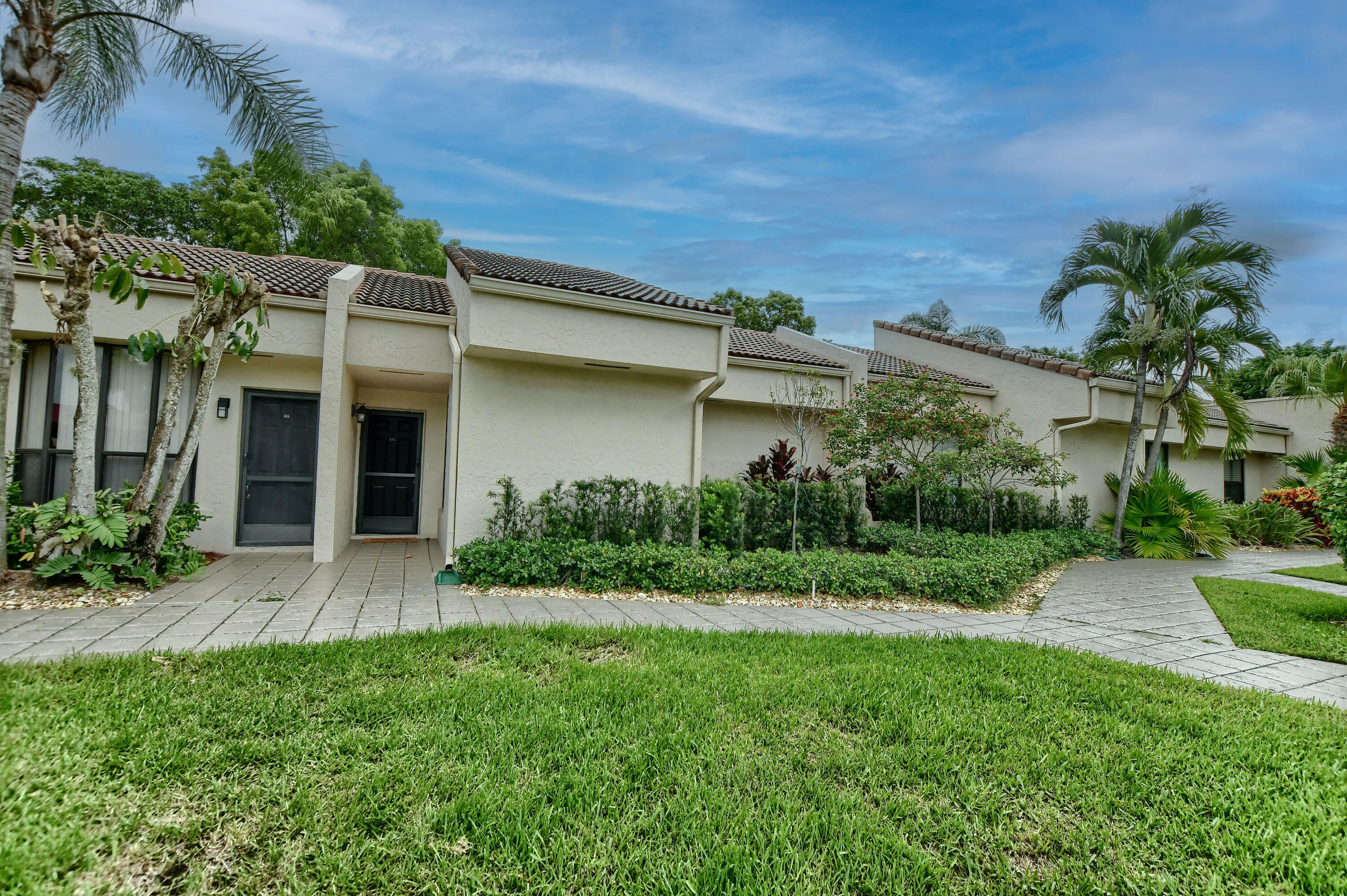7495 La Paz Boulevard, Unit 105 Boca Raton, FL 33433 - Photo 24 of 29 a view of a house with a yard and plants