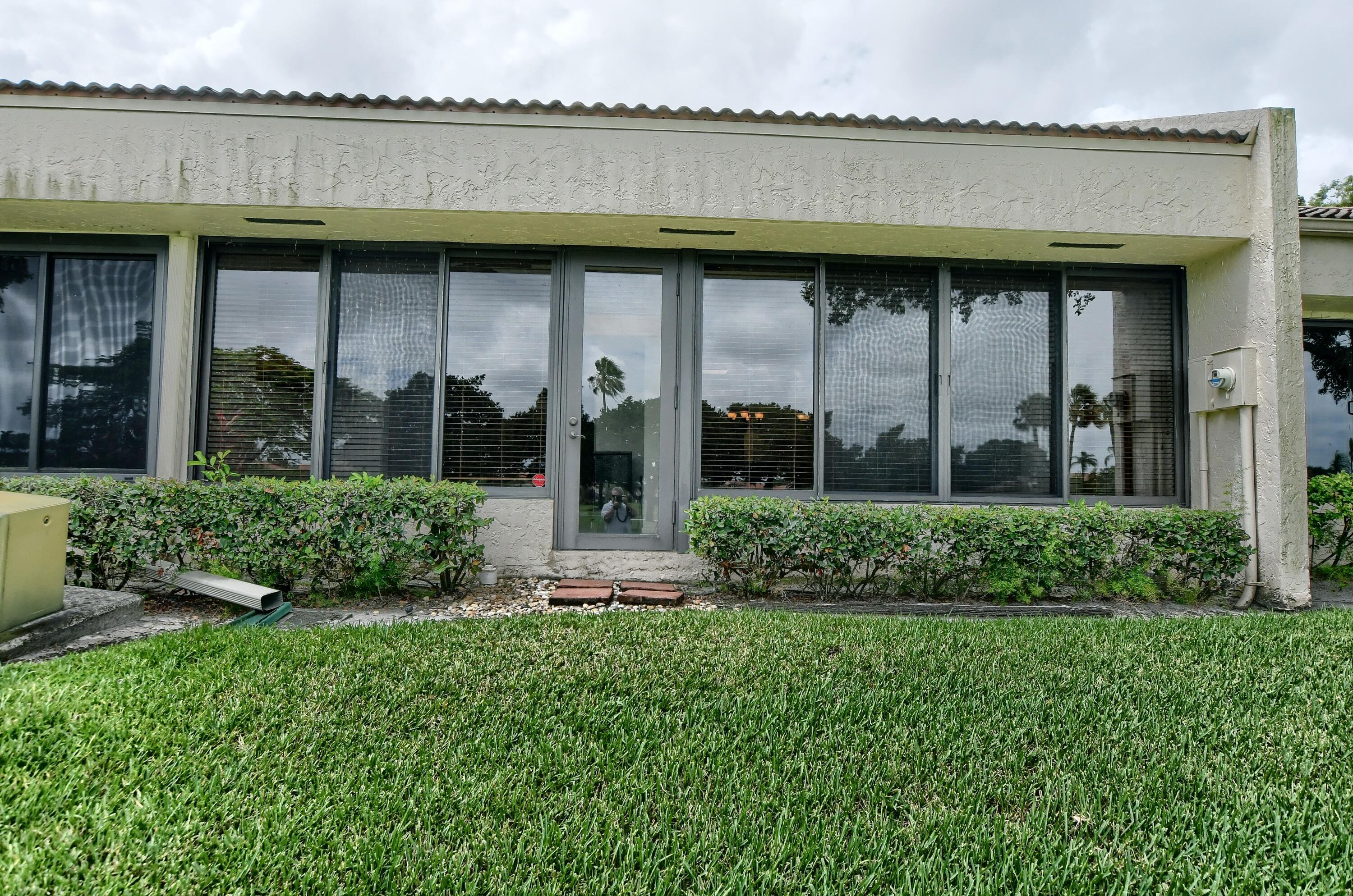 7495 La Paz Boulevard, Unit 105 Boca Raton, FL 33433 - Photo 25 of 29 a view of a house with potted plants and a large window