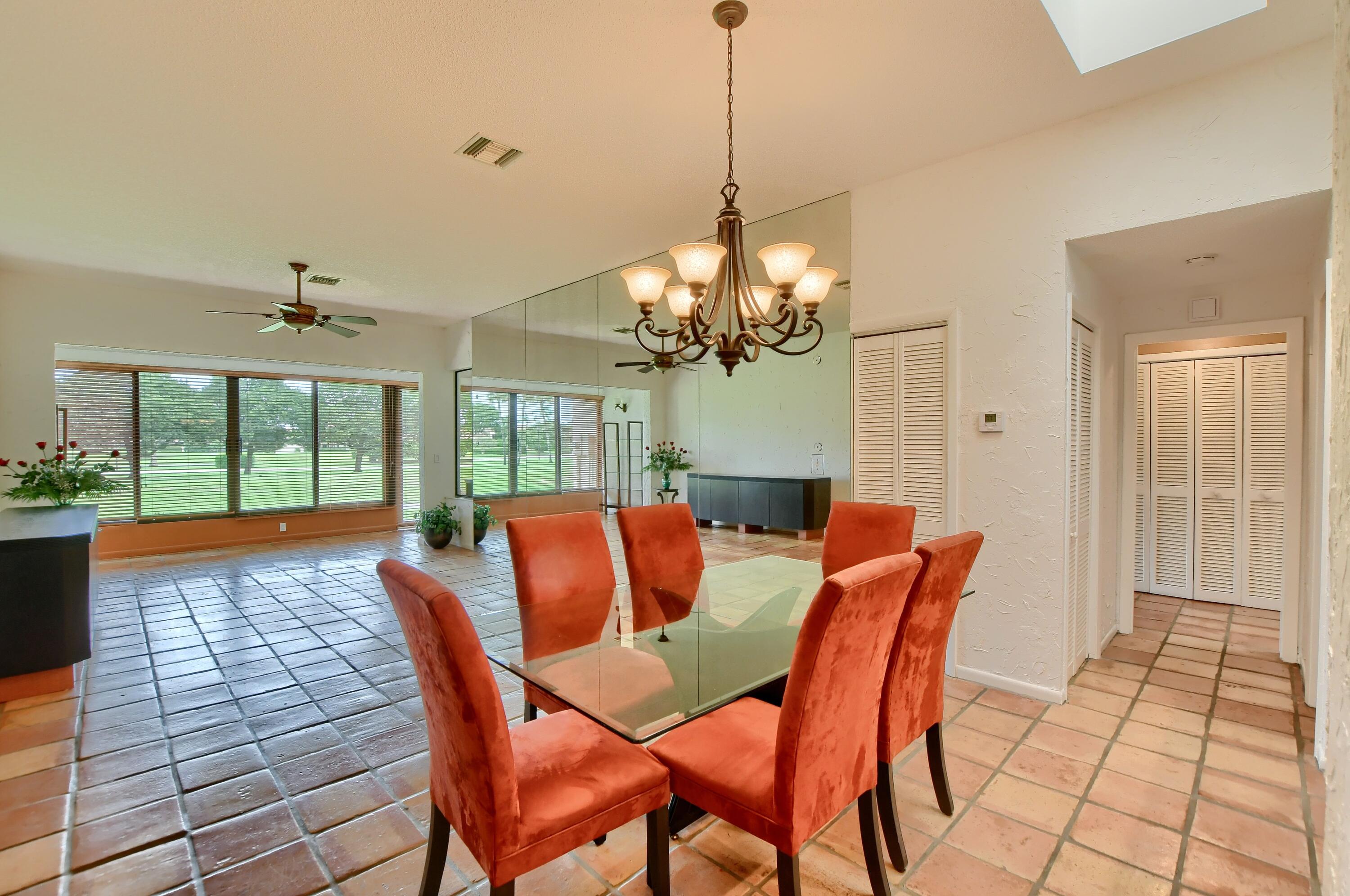 7495 La Paz Boulevard, Unit 105 Boca Raton, FL 33433 - Photo 3 of 29 a dining room with furniture a chandelier and wooden floor