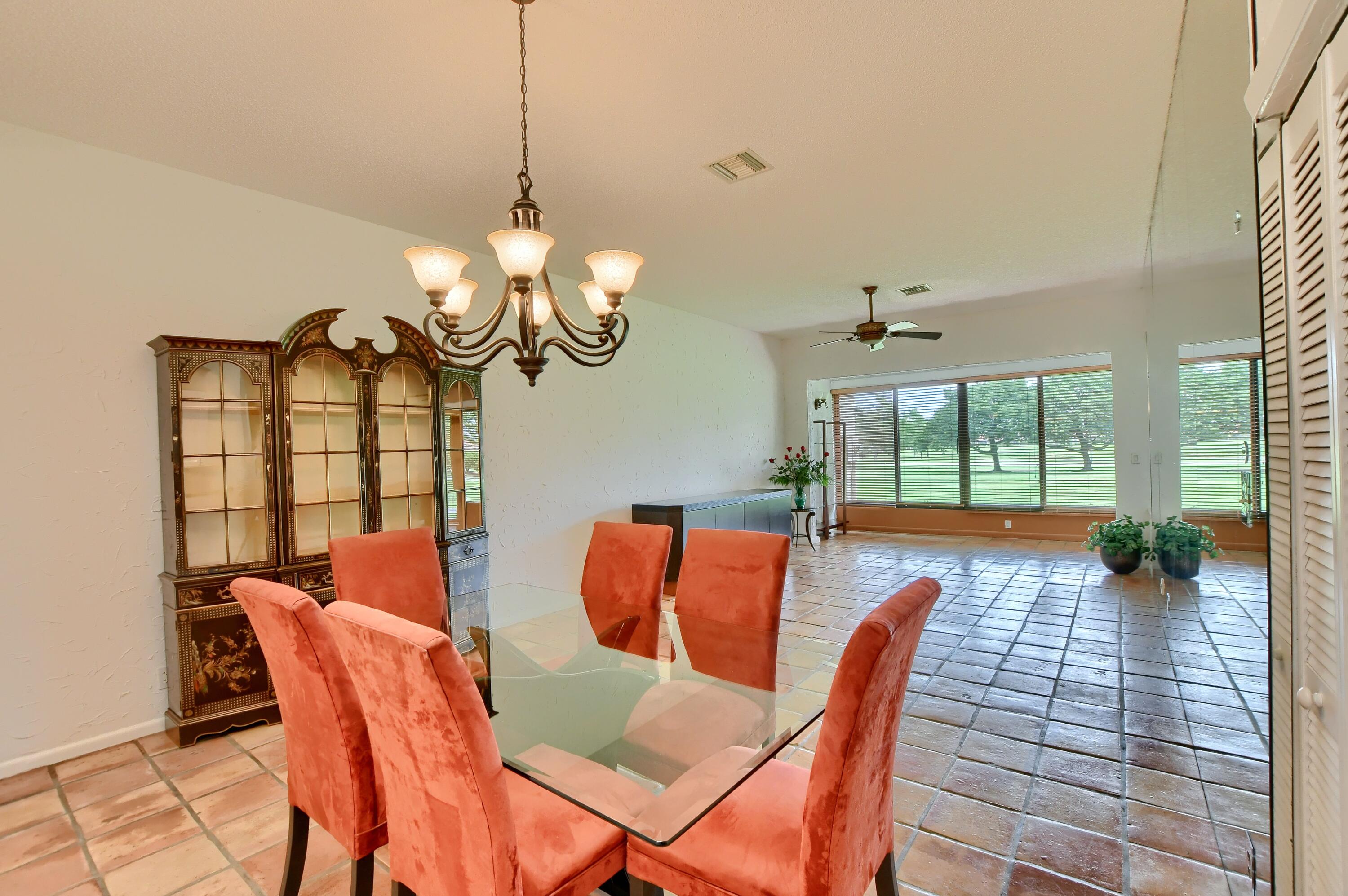 7495 La Paz Boulevard, Unit 105 Boca Raton, FL 33433 - Photo 4 of 29 a dining room with furniture a chandelier and wooden floor