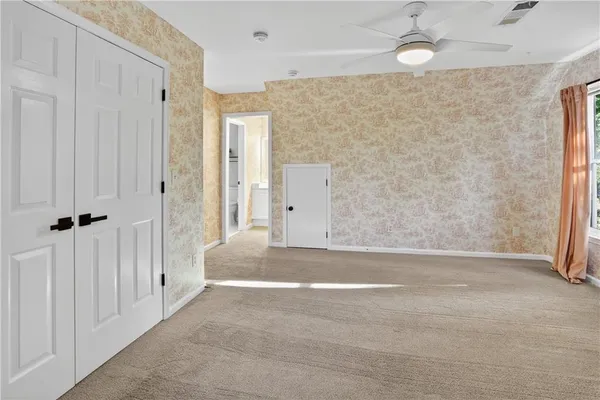 a view of an empty room with a ceiling fan