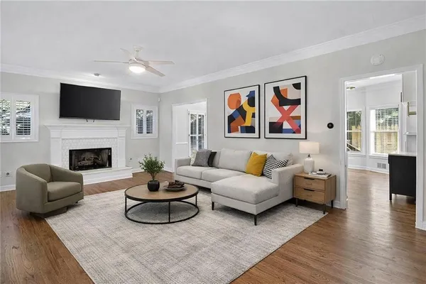 an empty room with wooden floor fireplace and windows