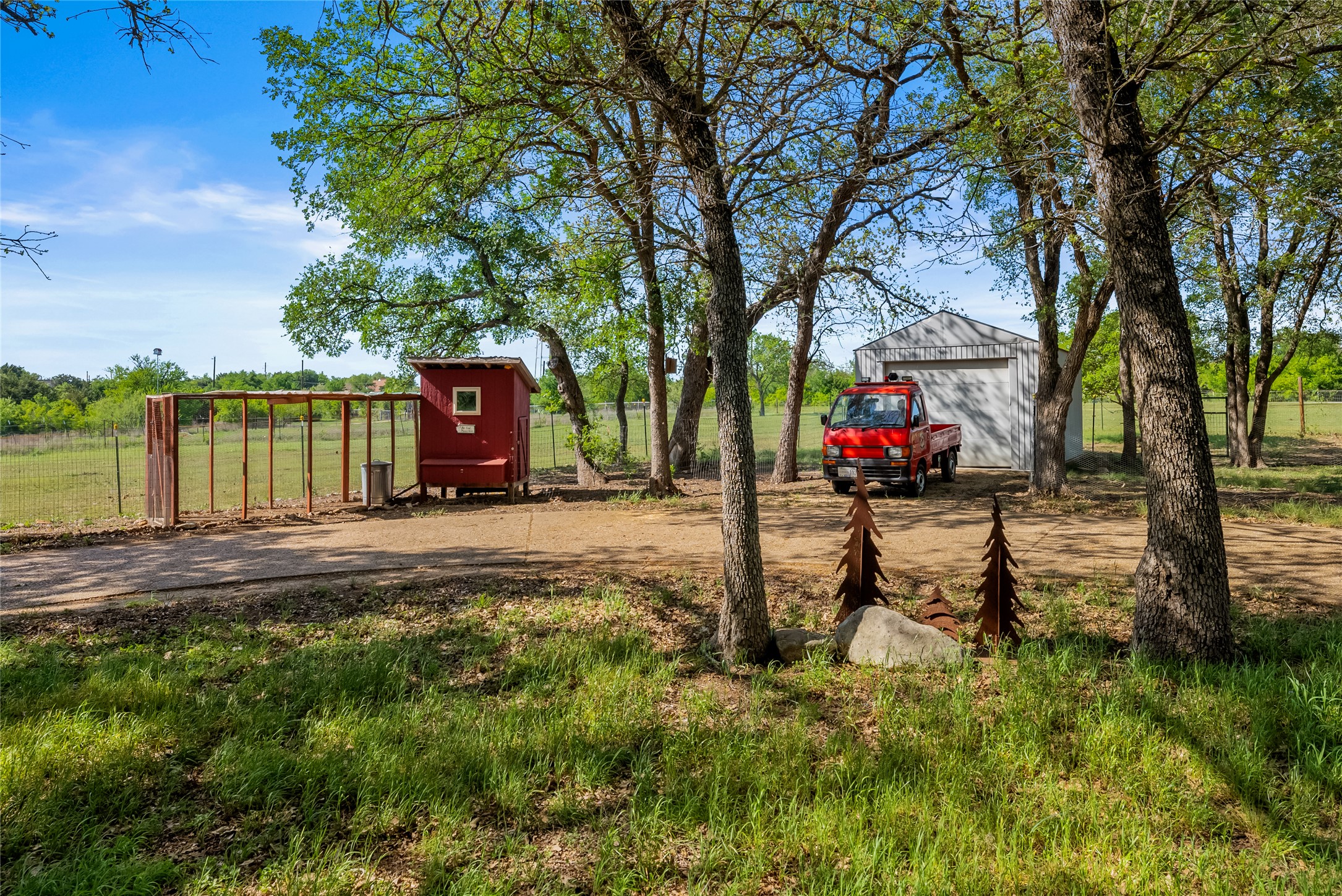 7670 Nez Perce Trace Manor, TX 78653 - Photo 38 of 40 View of yard featuring a detached garage, dirt driveway, an outdoor structure, and exterior structure