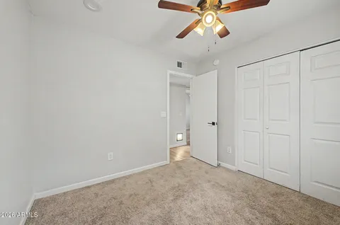 a view of an empty room and chandelier fan