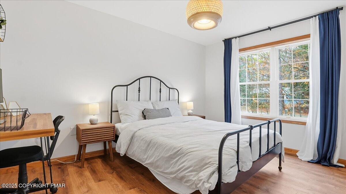 163 Long Woods Road Tobyhanna, PA 18466 - Photo 18 of 52 a bedroom with a bed a chandelier and a window