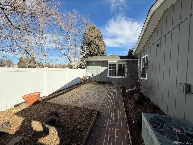 a balcony with wooden floor and a potted plant