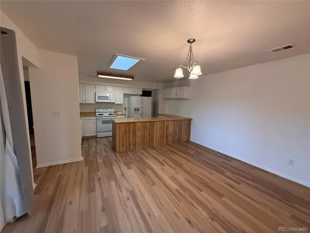 a view of kitchen and hallway with wooden floor