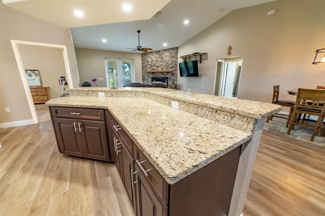 a kitchen with granite countertop kitchen island wooden cabinets counter top space and stainless steel appliances
