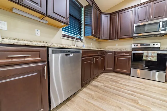 a kitchen with stainless steel appliances granite countertop a stove microwave and cabinets