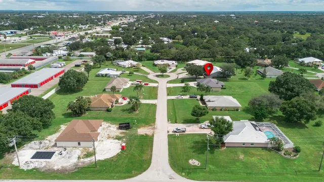 an aerial view of residential houses with outdoor space and trees