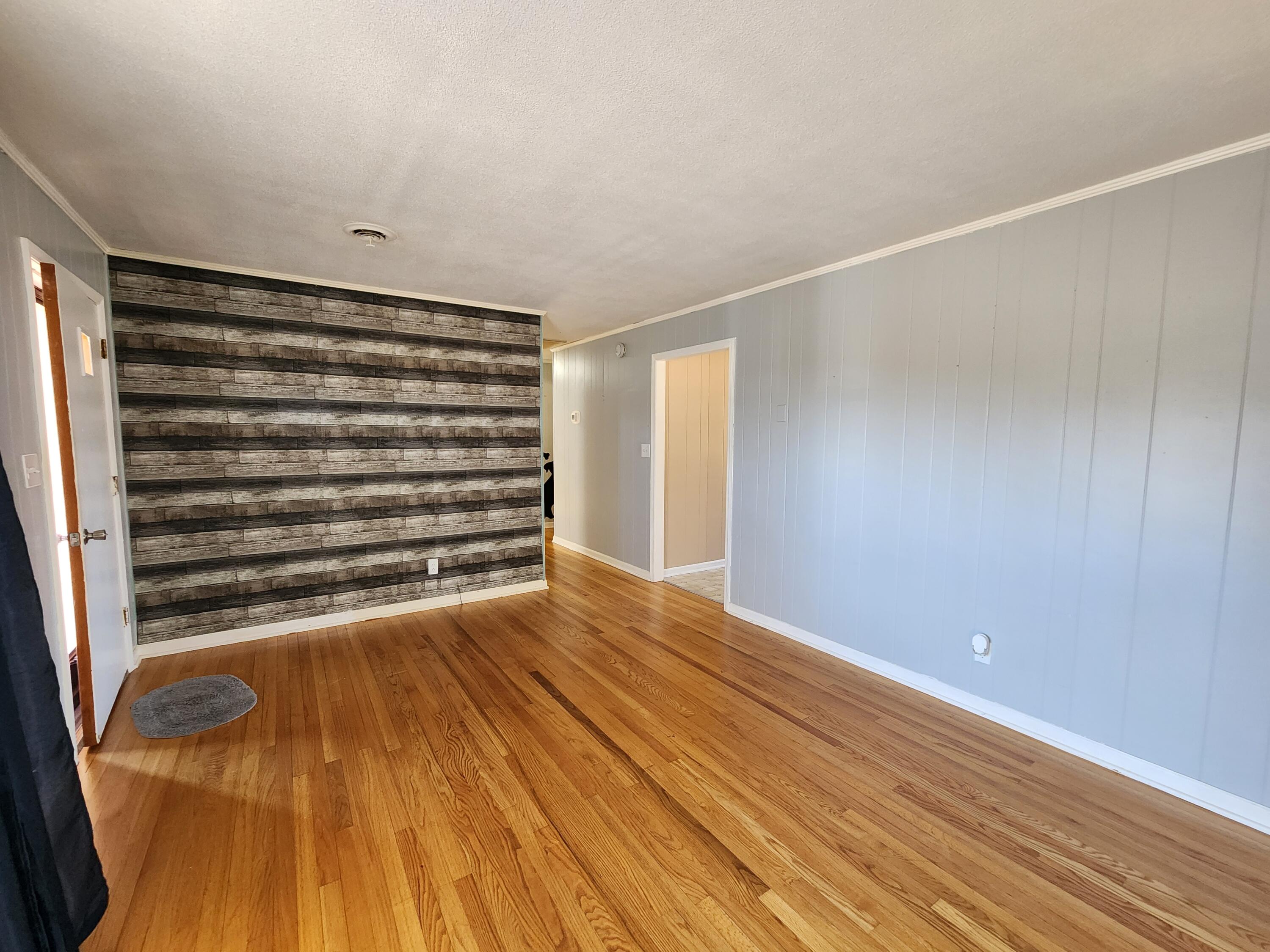 10519 Henry Road Henry, VA 24102 - Photo 4 of 25 a view of an empty room with wooden floor and a window