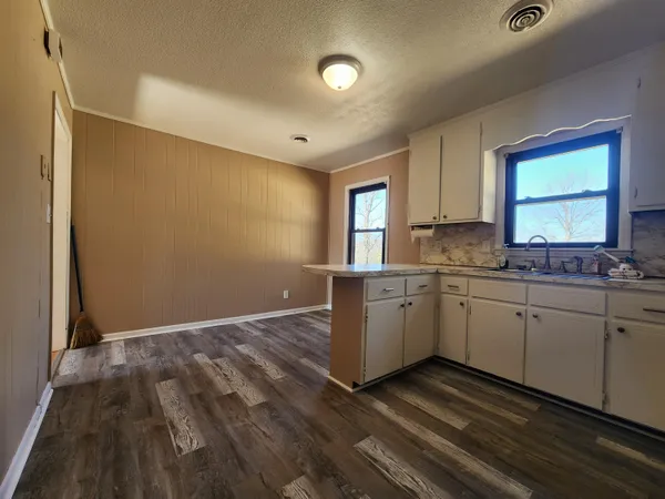 a kitchen with granite countertop white cabinets and white appliances