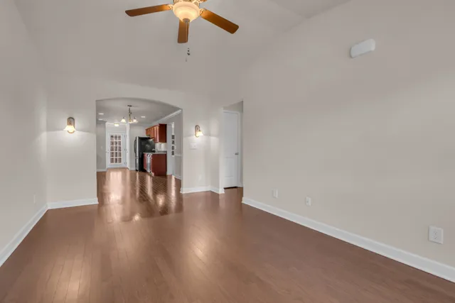 a kitchen with stainless steel appliances granite countertop a stove top oven a refrigerator a sink and dishwasher wooden cabinets with wooden floor