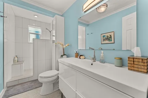a bathroom with a sink a toilet and shower