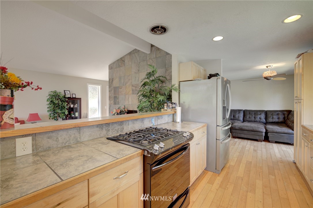 1 172nd Place Southwest Bothell, WA 98012 - Photo 9 of 27 a kitchen with stainless steel appliances granite countertop a refrigerator and a stove top oven
