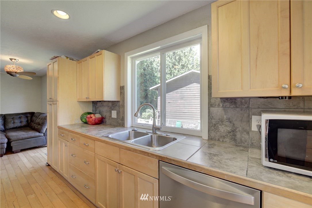 1 172nd Place Southwest Bothell, WA 98012 - Photo 10 of 27 a kitchen with stainless steel appliances granite countertop a sink a microwave cabinets and a counter space