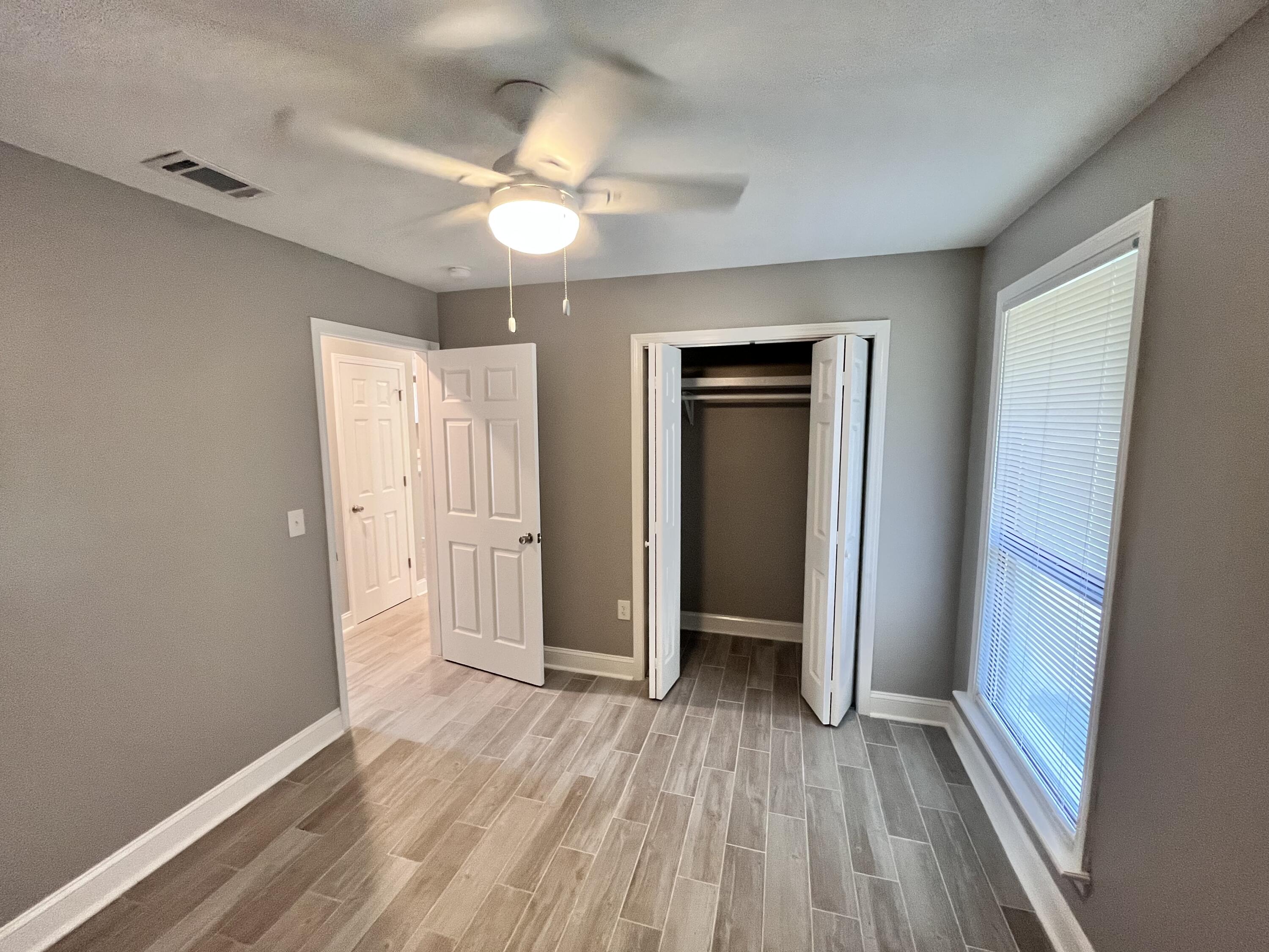 795 Bay Street Crestview, FL 32536 - Photo 14 of 16 wooden floor in an empty room with a mirror