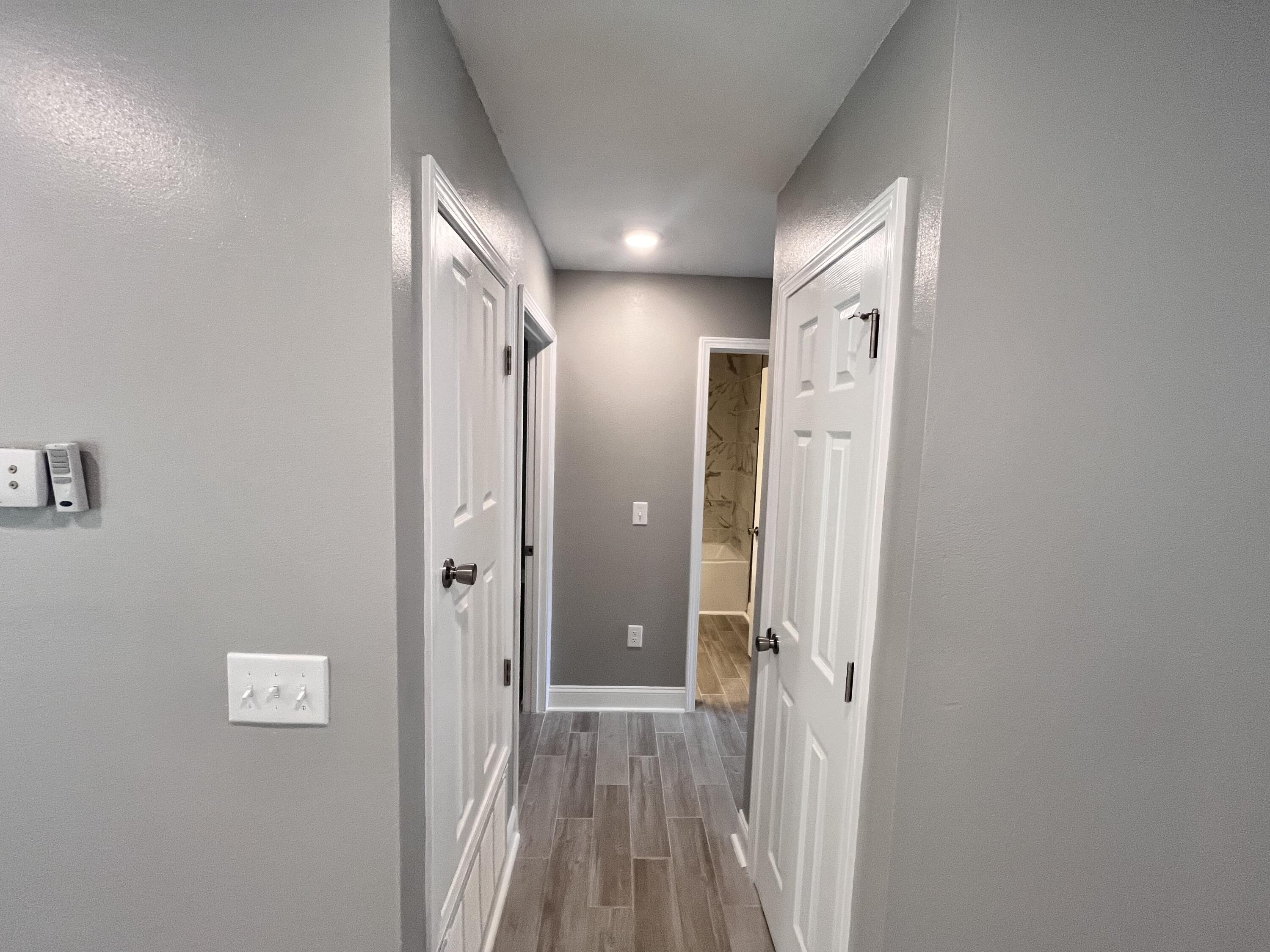 795 Bay Street Crestview, FL 32536 - Photo 8 of 16 a view of a hallway with wooden floor and a bathroom