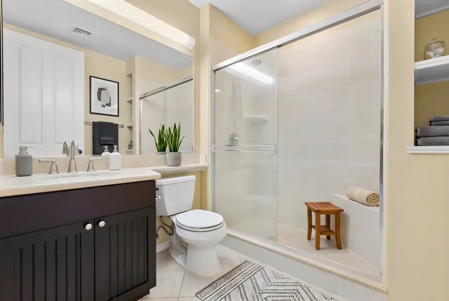 a bathroom with a sink toilet a mirror and shower