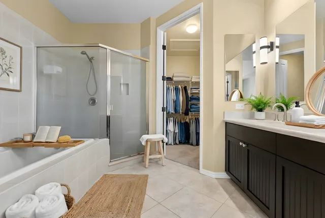 a spacious bathroom with a double vanity sink a large mirror a bathtub and shower