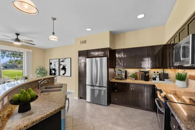 a kitchen with granite countertop a sink stainless steel appliances and cabinets