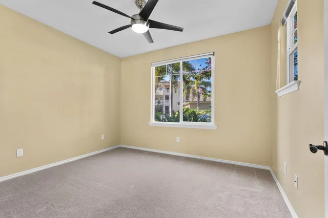 an empty room with windows and fan