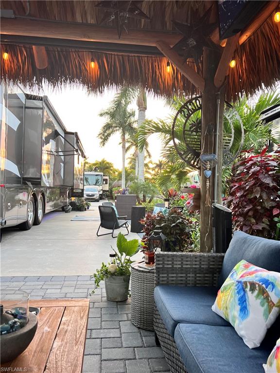 13575 Snook Circle Naples, FL 34114 - Photo 22 of 50 a view of a patio with couches and chairs under an umbrella