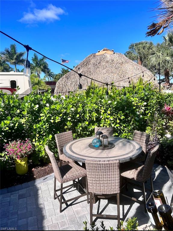 13575 Snook Circle Naples, FL 34114 - Photo 24 of 50 a patio with a table and chairs and potted plants