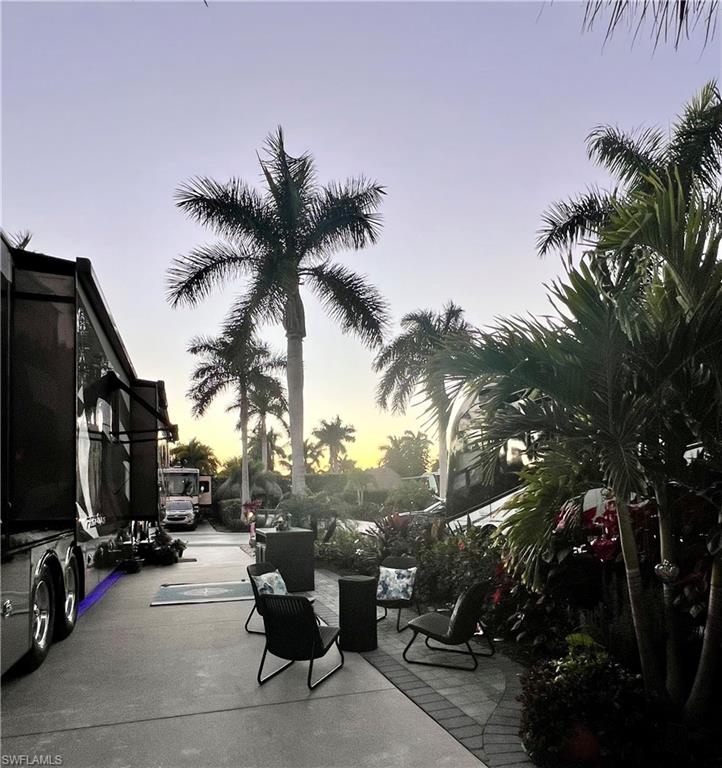 13575 Snook Circle Naples, FL 34114 - Photo 29 of 50 a view of a patio with a table and chairs potted plants and palm trees