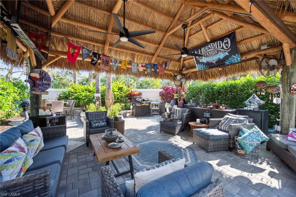 13575 Snook Circle Naples, FL 34114 - Photo 48 of 50 a outdoor living space with furniture and a black umbrella