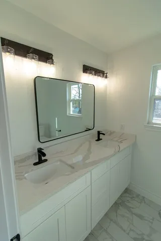 a bathroom with a sink a mirror and shower