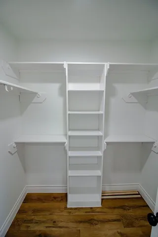 a view of walk in closet with empty racks