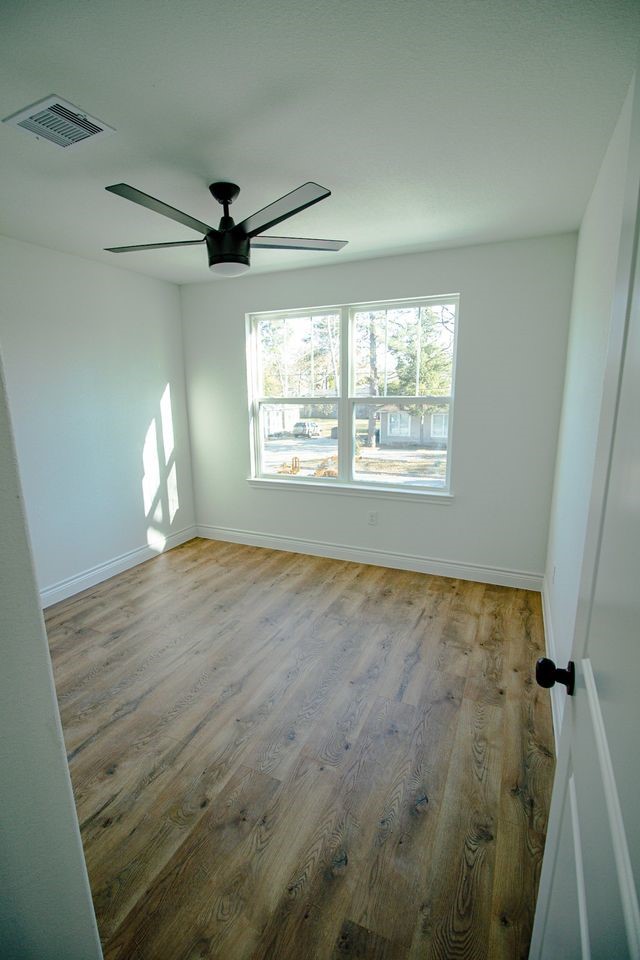 1407 Odd Fellow Street, Unit A Conroe, TX 77301 - Photo 9 of 16 a view of empty room with wooden floor and fan