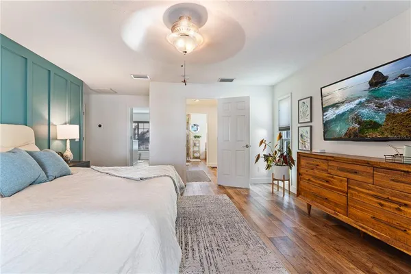 a spacious bedroom with a bed and a flat screen tv
