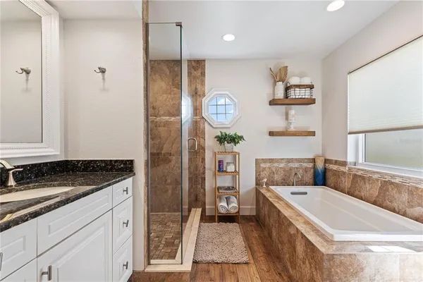 a bathroom with a granite countertop sink a toilet a mirror and shower