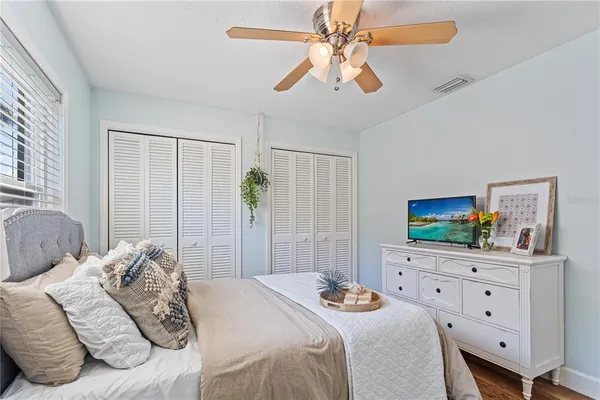 a bedroom with a bed a window and a flat screen television