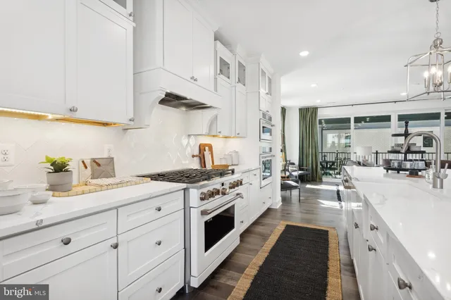 a kitchen with stainless steel appliances a sink stove and cabinets