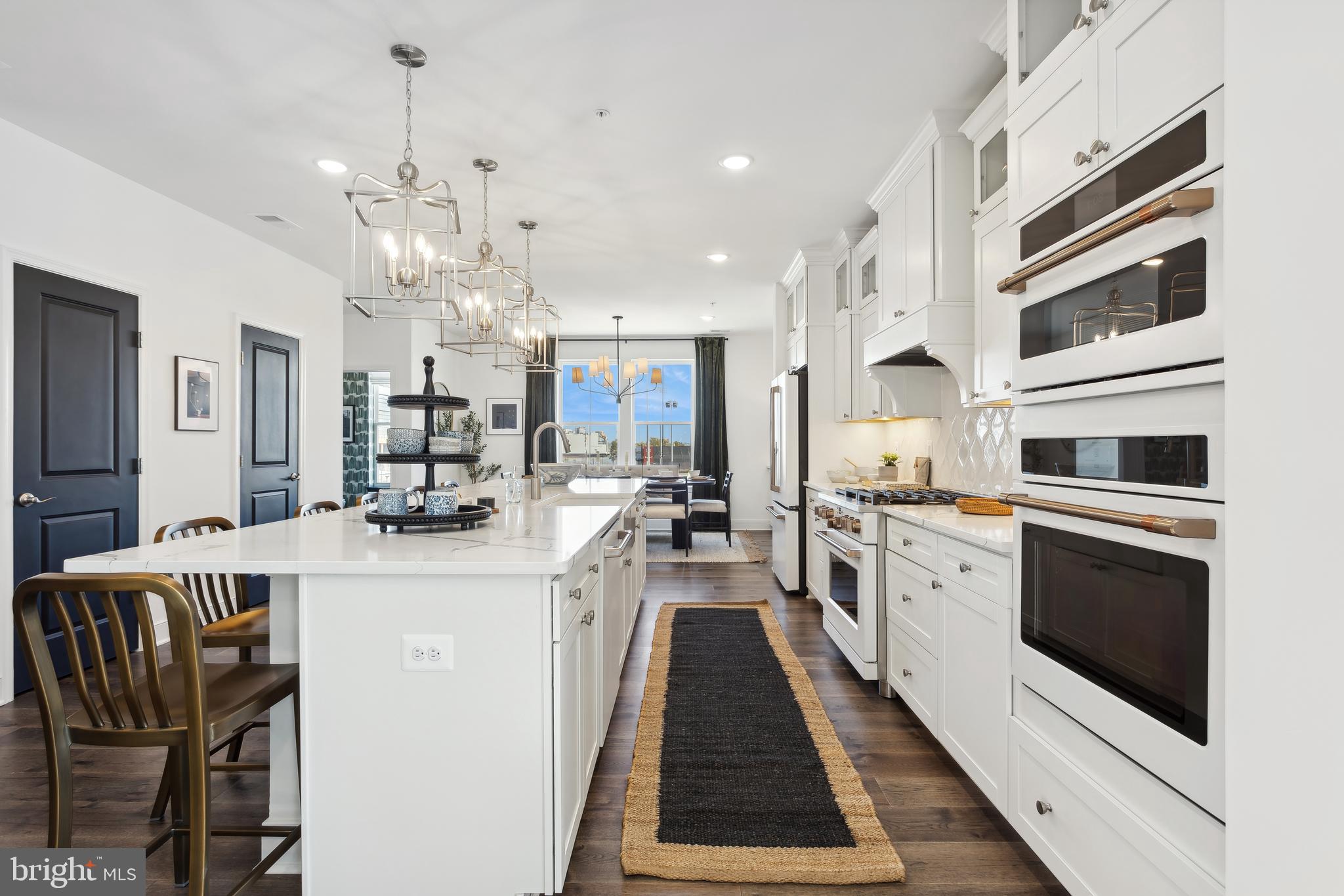 128 Locke Street, Unit 2029 Baltimore, MD 21230 - Photo 14 of 29 a kitchen with stainless steel appliances kitchen island granite countertop a stove top oven a sink a dining table and chairs