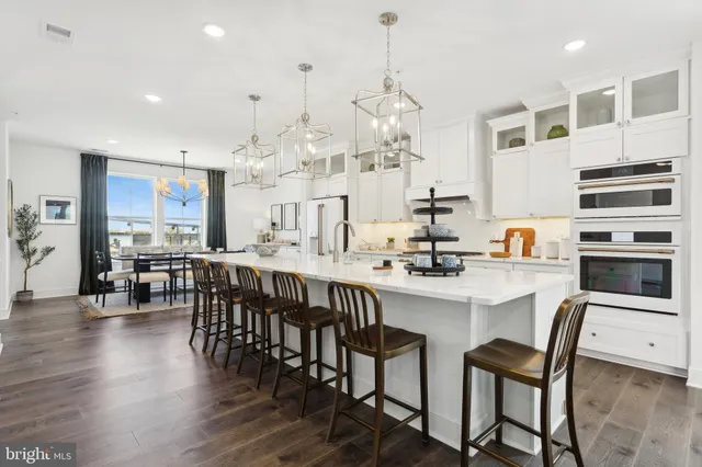 a kitchen with stainless steel appliances kitchen island granite countertop a table and chairs in it