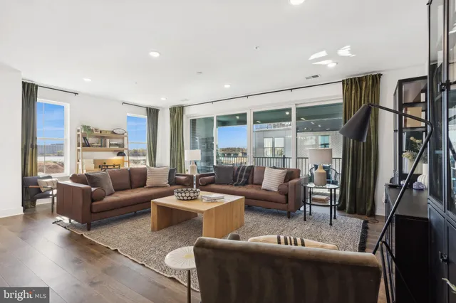 a living room with furniture flat screen tv and a large window