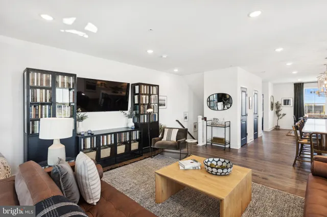 a living room with furniture and a table with wooden floor