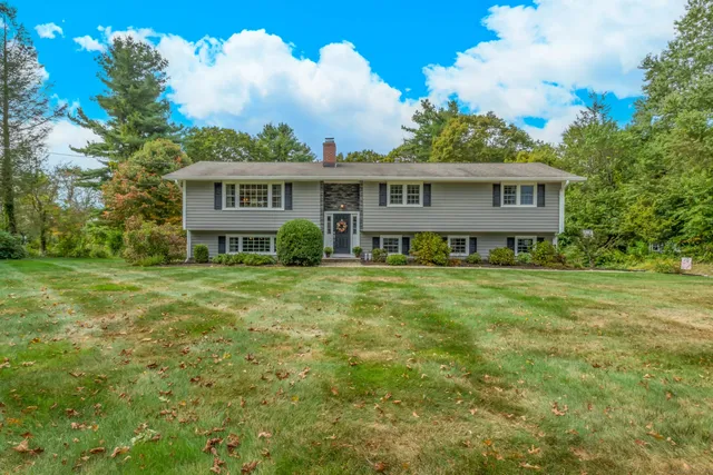 a view of a house with a big yard and potted plants