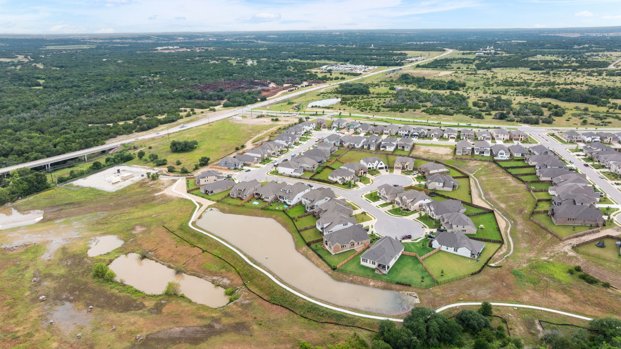 515 Watershield Cove Georgetown, TX 78633 - Photo 40 of 40 An aerial perspective reveals a developing neighborhood nestled amidst green landscapes and connected by roadways.