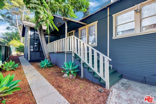 a view of a house with wooden stairs and a table and chair