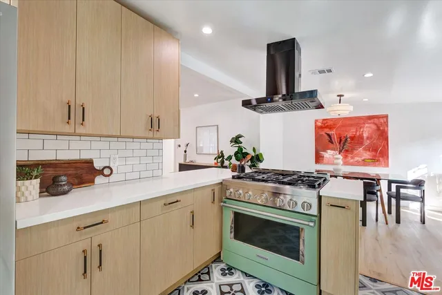 a kitchen with stainless steel appliances a stove a sink and white cabinets