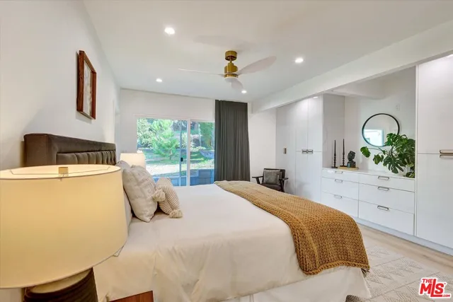 a bedroom with a large bed and a potted plant