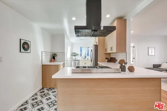 a kitchen with kitchen island granite countertop a sink a counter top space and cabinets