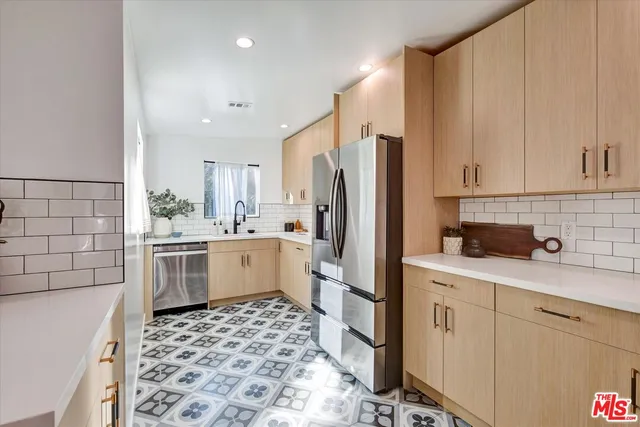 a kitchen with a sink a refrigerator and cabinets